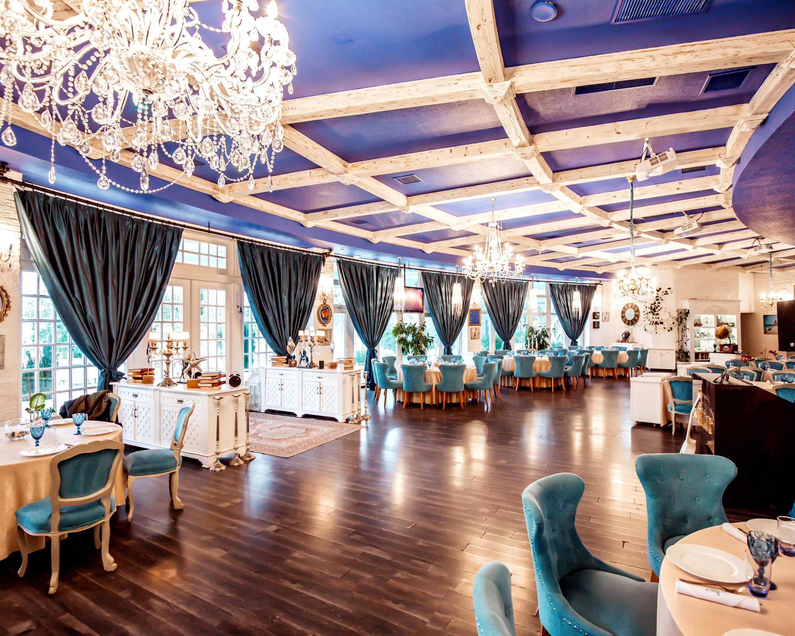 restaurant hall with turquoise chairs french windows navy coloured ceiling